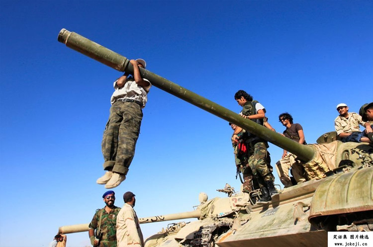 利比亚，巴尼瓦利德（Bani Walid）北部，一名反卡扎菲武装人员在坦克上做引体向上运动