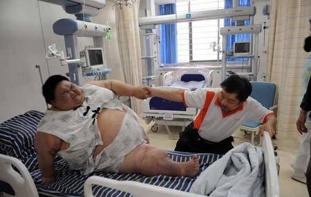 父亲吃力地将梁用从病床上拉起来